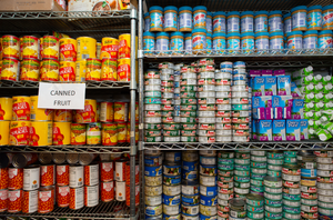 Food pantry shelves stocked with canned goods.